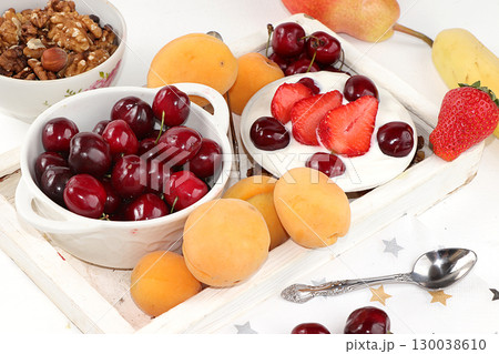 Fruit salad, Healthy breakfast with ingredients, yogurt with granola, strawberries, cherries and peaches on a light table. The concept of healthy and natural food, lifestyle. selective focus Fruit salad, Healthy breakfast with ingredients, yogurt with granola, strawberries, cherries and peaches on a light table. The concept of healthy and natural food, lifestyle. selective focus 130038610