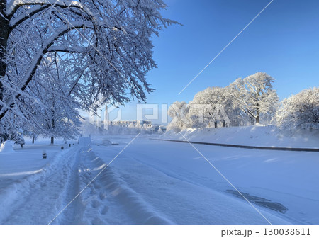 A picturesque winter landscape in Parnu, Estonia with a snow-covered path running along a riverbank A picturesque winter landscape in Parnu, Estonia with a snow-covered path running along a riverbank 130038611