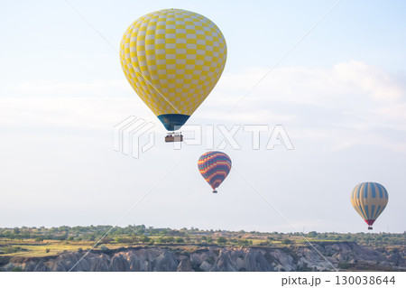Hot air balloons soaring above the stunning landscapes of Cappadocia, Turkey during sunrise 130038644