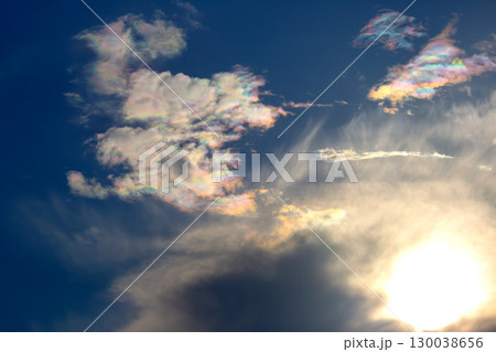 Colorful clouds reflect sunlight during sunset over a clear sky Colorful clouds reflect sunlight during sunset over a clear sky 130038656