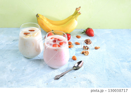 Strawberry and banana smoothies, yogurt with berries and honey on a bright table.Useful breakfast  with ingredients. Healthy and natural food concept, lifestyle, selective focus, place for text 130038717
