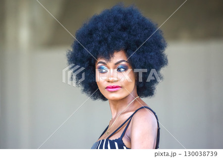 Elegance and confidence of an African woman with natural afro hairstyle during outdoor event 130038739