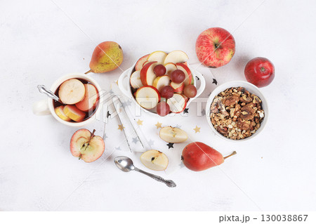 Healthy breakfast, food for children, fruit salad with apples, pears, grapes on a bright table. The concept of healthy and natural food, lifestyle, promotes weight loss, top view Healthy breakfast, food for children, fruit salad with apples, pears, grapes on a bright table. The concept of healthy and natural food, lifestyle, promotes weight loss, top view 130038867