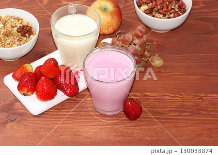 Strawberry and apple smoothie and granola, granola, fresh berries, apples, strawberries and grapes on a wooden sunny background. The concept of healthy and natural food. Healthy breakfast, food for Strawberry and apple smoothie and granola, granola, fresh berries, apples, strawberries and grapes on a wooden sunny background. The concept of healthy and natural food. Healthy breakfast, food for 130038874