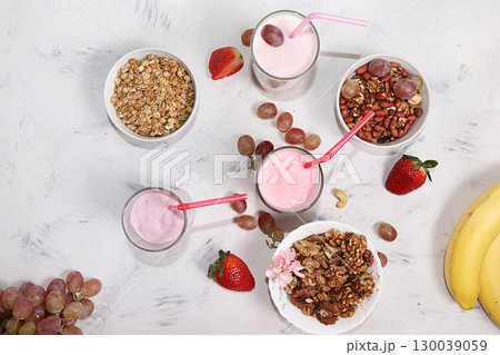 Strawberry and apple smoothie and granola, granola, fresh berries, strawberries and grapes on a wooden sunny background. The concept of healthy and natural food. Healthy breakfast, food for children, 130039059