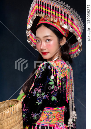 Beautiful Asian woman wearing traditional colorful ethnic costume and silver jewelry, posing in studio portrait. Cultural fashion photography showcasing vibrant embroidery, handmade textile. Beautiful Asian woman wearing traditional colorful ethnic costume and silver jewelry, posing in studio portrait. Cultural fashion photography showcasing vibrant embroidery, handmade textile. 130039271