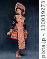 Beautiful Asian woman wearing traditional colorful ethnic costume and silver jewelry, posing in studio portrait. Cultural fashion photography showcasing vibrant embroidery, handmade textile. 130039273