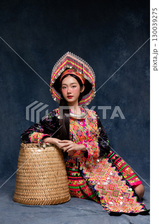 Beautiful Asian woman wearing traditional colorful ethnic costume and silver jewelry, posing in studio portrait. Cultural fashion photography showcasing vibrant embroidery, handmade textile. Beautiful Asian woman wearing traditional colorful ethnic costume and silver jewelry, posing in studio portrait. Cultural fashion photography showcasing vibrant embroidery, handmade textile. 130039275