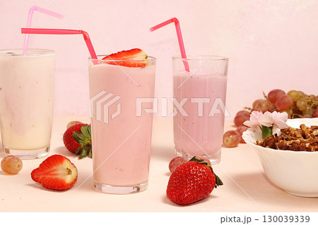 Strawberry and banana smoothies, granola, fresh berries and grapes on a pink sunny background. The concept of healthy and natural food. Useful breakfast, Strawberry and banana smoothies, granola, fresh berries and grapes on a pink sunny background. The concept of healthy and natural food. Useful breakfast, 130039339