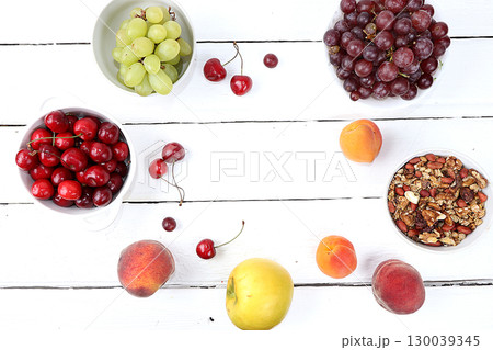 Healthy breakfast with ingredients, food for children, summer fruits and berries with granola, grapes, cherries and peaches on a bright table. The concept of a healthy and natural diet, lifestyle, 130039345
