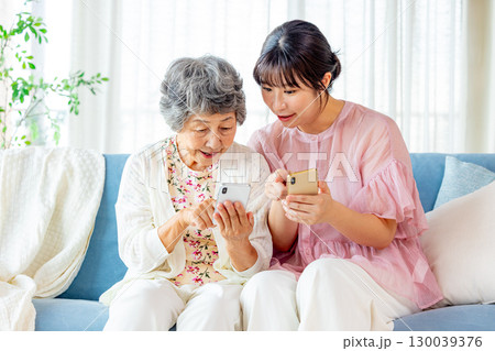 スマホを見るシニア　孫娘 130039376