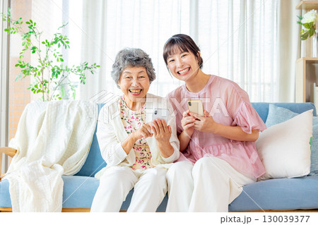 スマホを見るシニア　孫娘 130039377