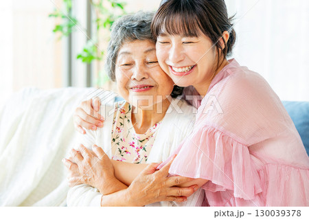 寄り添う笑顔のシニア女性と若い女性 130039378