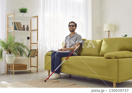 Blind Man Reading Braille Book On Sofa At Home Blind Man Reading Braille Book On Sofa At Home 130039737