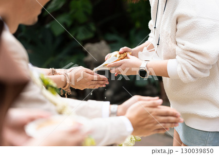 Thai wedding, Person pouring water over hands in traditional ceremony outdoors with cultural significance 130039850