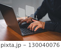Close-up of hands typing on a laptop with digital chat bubbles. Concept of online communication, virtual consultation, doctor chat help guide online or telemedicine support in a modern workspace. 130040076