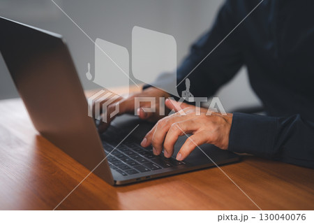 Close-up of hands typing on a laptop with digital chat bubbles. Concept of online communication, virtual consultation, doctor chat help guide online or telemedicine support in a modern workspace. 130040076