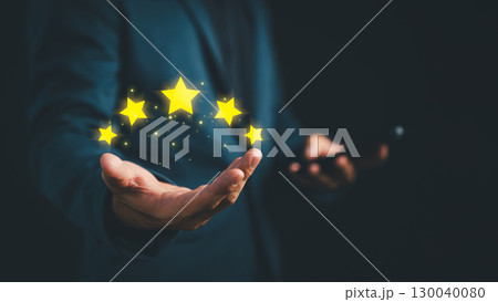 Businessman presenting five glowing stars above his hand, symbolizing top-rated customer service, customer satisfaction, or quality assurance in digital marketing and business evaluation concept. 130040080