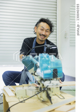 電動丸鋸で作業する職人 130040393