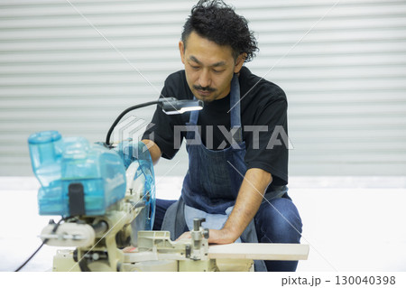 電動丸鋸で作業する職人 130040398