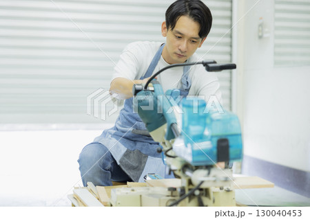 電動丸鋸で作業する職人　 130040453