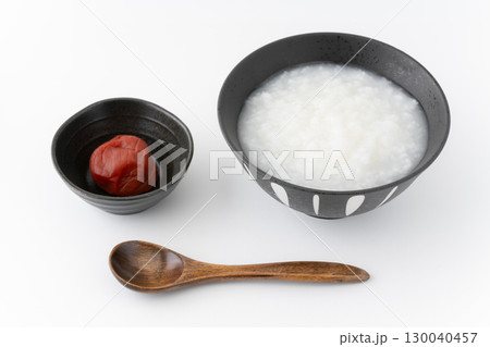 白背景に梅干しとお茶碗に入ったお粥 130040457