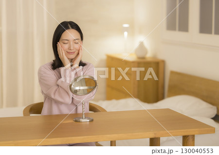 寝室で夜スキンケアをする女性 130040553