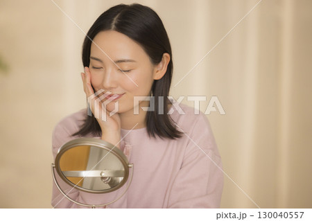 寝室で夜スキンケアをする女性 寝室で夜スキンケアをする女性 130040557
