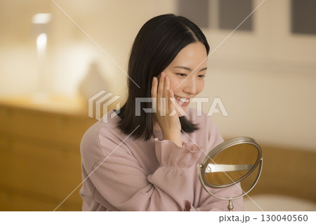 寝室で夜スキンケアをする女性 寝室で夜スキンケアをする女性 130040560