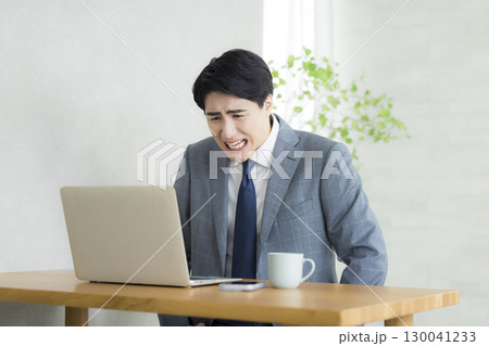 頭を抱えるビジネスマン 130041233