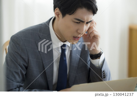 頭を抱えるビジネスマン 130041237