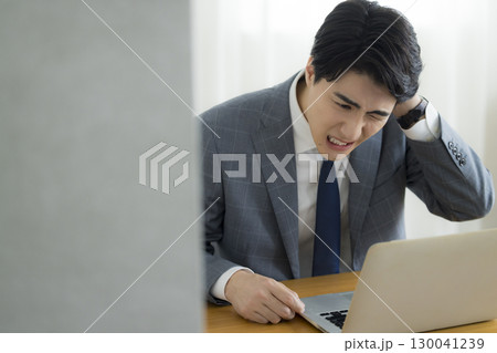 頭を抱えるビジネスマン 130041239