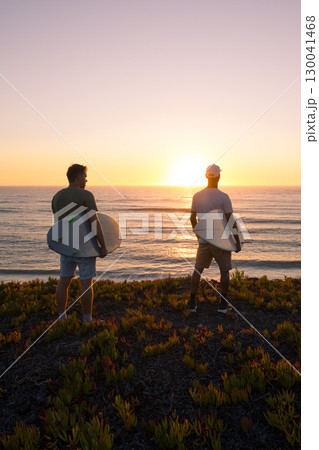 Surfers watching the waves at sunset Surfers watching the waves at sunset 130041468