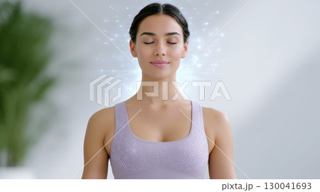 Young woman meditating with closed eyes and digital network overlay 130041693