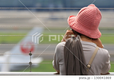 空港の展望デッキから飛行機を眺める女性 空港の展望デッキから飛行機を眺める女性 130041869