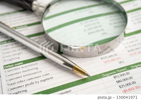 Magnifying glass on spreadsheet and graph paper. Magnifying glass on spreadsheet and graph paper. 130041971