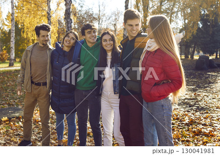 Portrait of a young happy smiling friends walking in the autumn park. 130041981