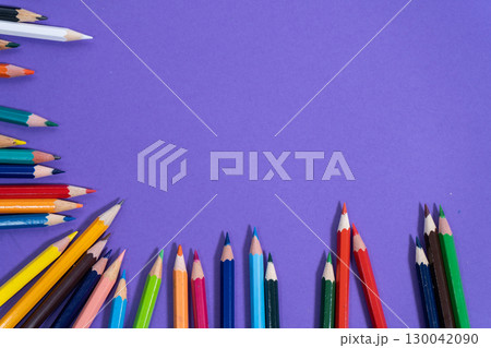 Colorful pencils forming a border on purple background with copy space 130042090