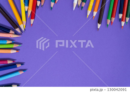 Colored pencils forming a colorful frame on purple background 130042091