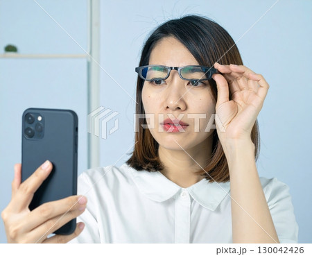 老眼で近くが見えない女性 130042426