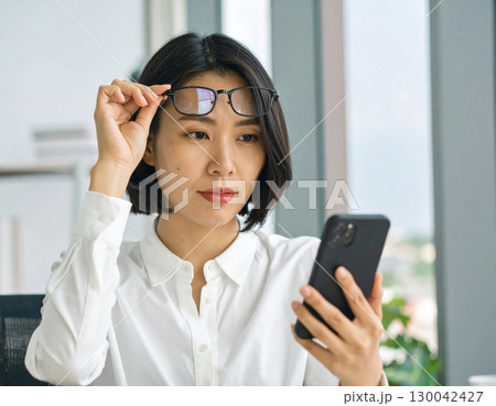 老眼で近くが見えない女性 130042427