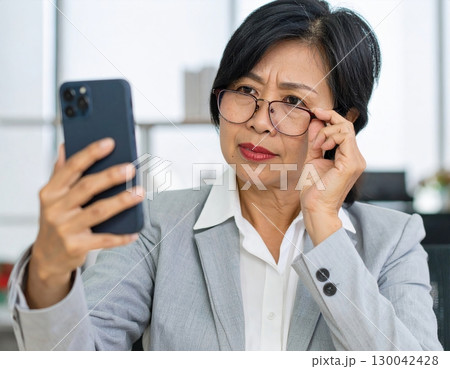 老眼で近くが見えない女性 130042428