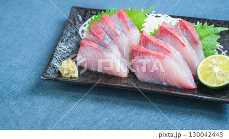 ハマチの刺身と大根のつま、すだちを添えた和食料理 130042443