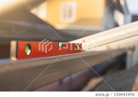 Construction worker use spirit level and measures the horizon of the iron beam in site. 130042950