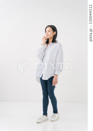 カジュアルなシャツとデニムを着た笑顔の女性 130044512