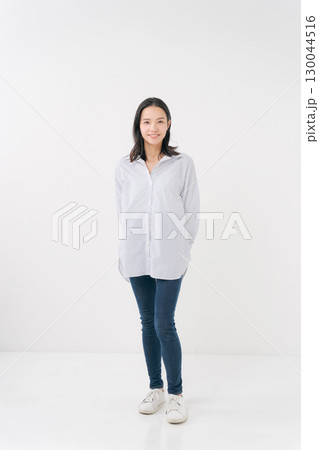カジュアルなシャツとデニムを着た笑顔の女性 130044516
