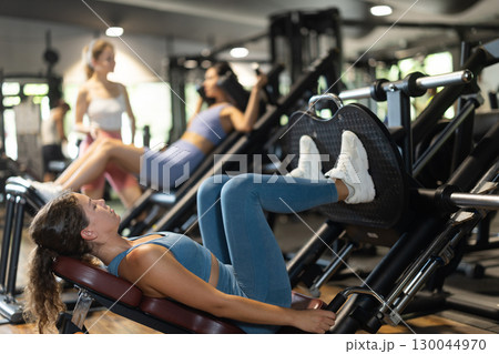 Woman doing leg press in machine Woman doing leg press in machine 130044970