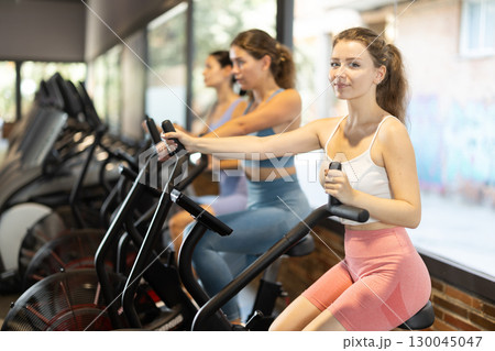 Woman on an airbike in the gym Woman on an airbike in the gym 130045047
