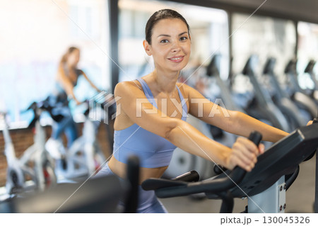Woman exercising on an exercise bike in the gym 130045326