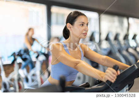 Woman exercising on an exercise bike in the gym 130045328